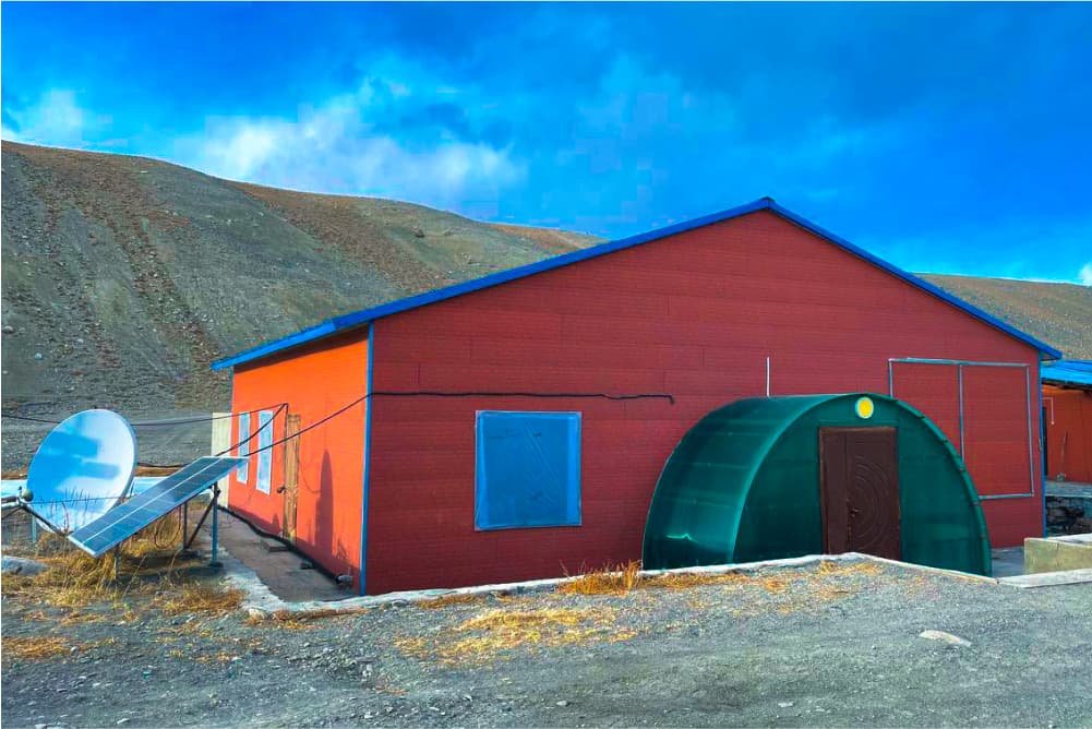 Red Hot Springs Camp building with a blue roof in the Pamir Mountains