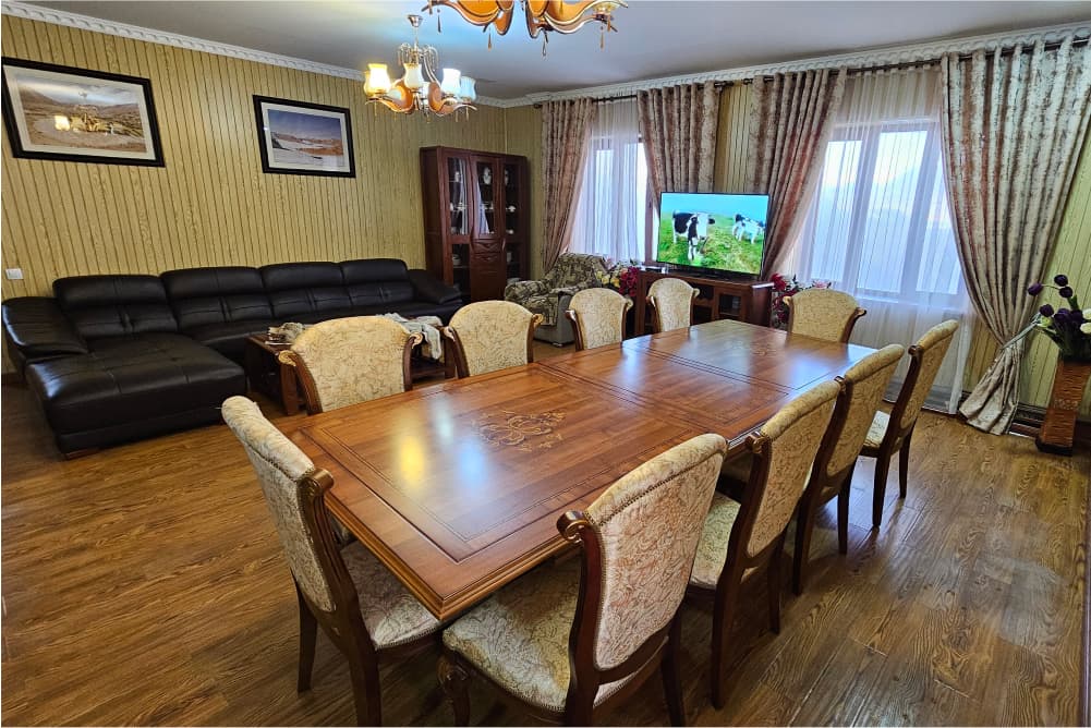 Camp dining room with a large wooden table, chairs and sofas